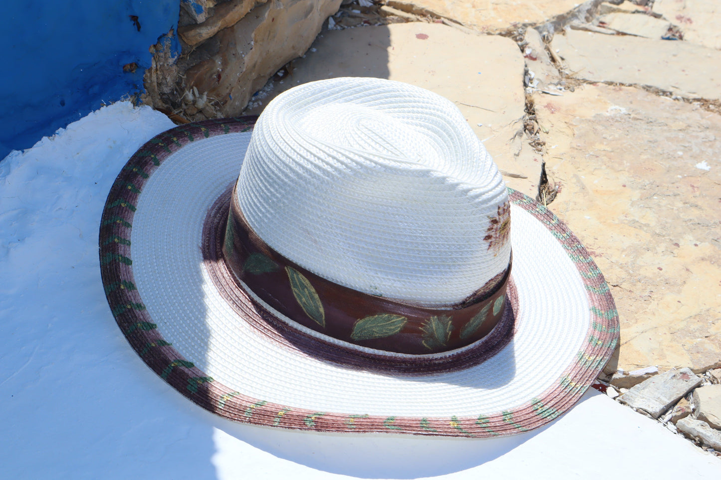   λευκό unisex ψάθινο καπέλο mousses greek art τύπου παναμά με καφέ κορδέλα και χειροποίητη ζωγραφική φύλλα ελιάς πάνω σε μια πέτρα 
