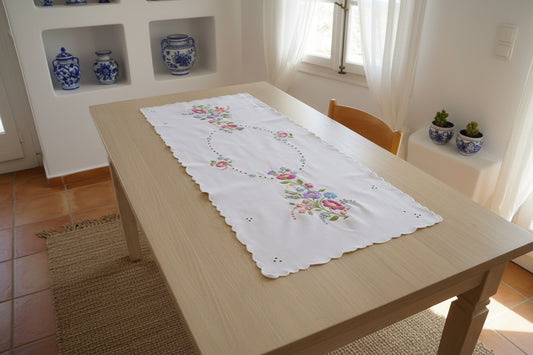 Ένα και μοναδικό (OOAK) χειροποίητο ρανερ Άνοιξη με πολύχρωμα λουλούδια και χειροποίητη φεστόνη σε άθικτη κατάσταση από τη συλλογή Mousses Greek Art. πάνω σε σ
ενόμακρο τραπέζι