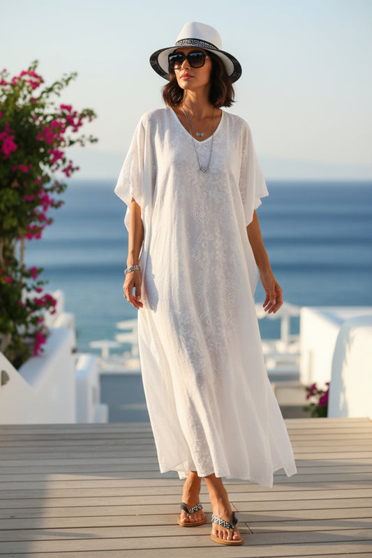 λευκό καπέλο  unisex ζωγραφισμενο στο χέρι σε γυναικα σε  μπροστά από θάλασσα και σανδάλια μαιανδρος ροδος 